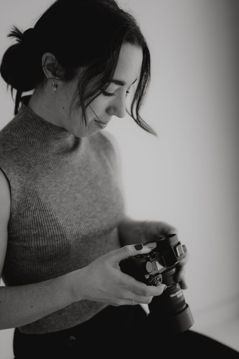 Portrait einer professionellen Hochzeitsfotografin aus Kärnten mit Kamera bei natürlichem Fotoshooting im Tageslichtstudio