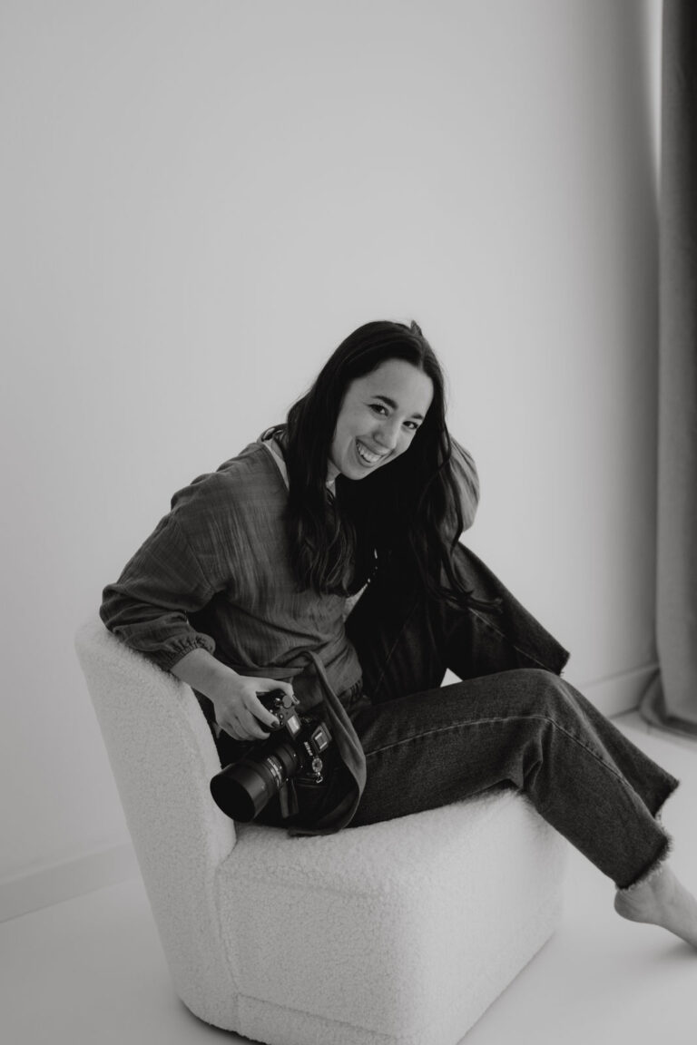 Portrait einer professionellen Hochzeitsfotografin aus Klagenfurt mit Kamera bei natürlichem Fotoshooting