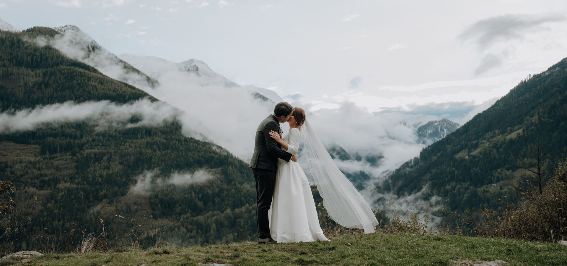 Hochzeitsfotografin fotografiert ein Brautpaar bei natürlichem Licht in den Bergen von Kärnten während eines romantischen Paarshootings