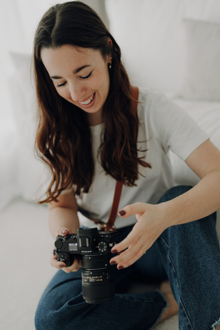Portrait einer professionellen Hochzeitsfotografin aus Feldkirchen mit Kamera bei natürlichem Fotoshooting