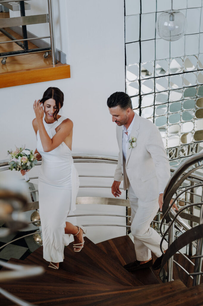 Brautpaar spaziert durch eine elegante Stadtstraße während eines City Wedding Shootings